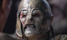 An orc in a helmet snarls and bears its teeth.